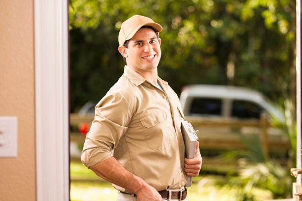 Pest control professional at a residential front door